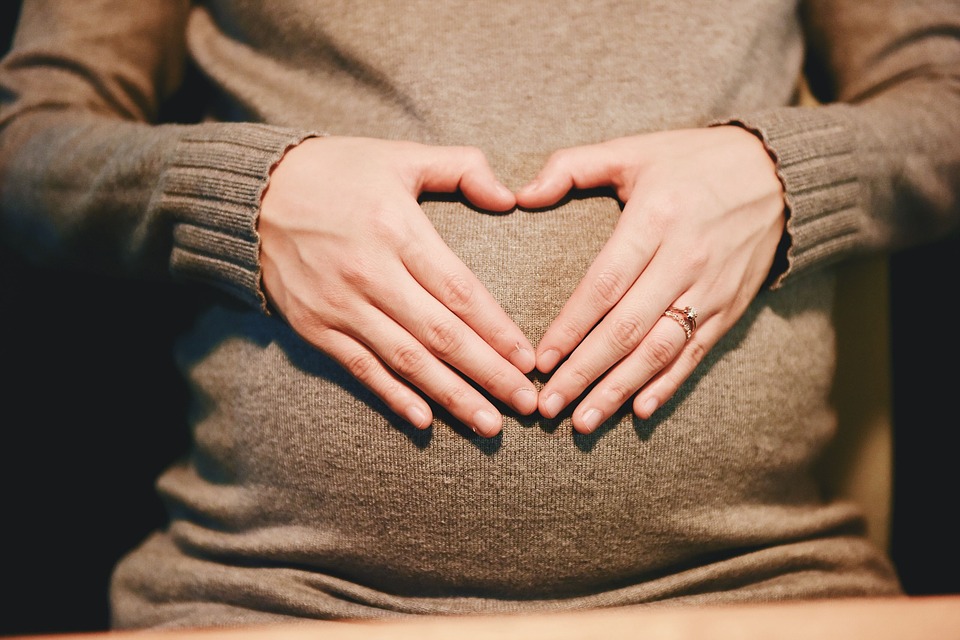 Gravid kvinde former hjerte på mave